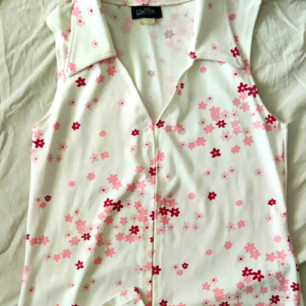 Sleeveless, low plunge v-neck top with pretty pink flowers. Belly vent.